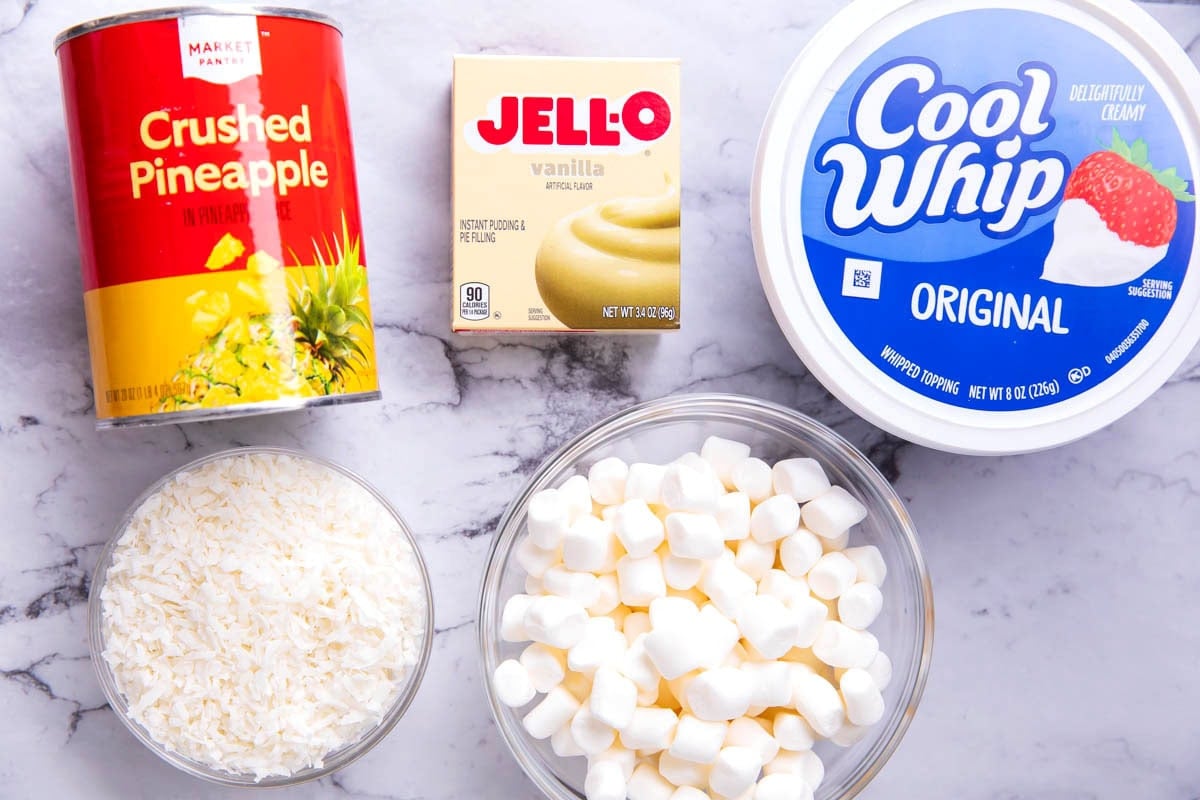 Old fashioned pineapple fluff recipe ingredients include coconut, vanilla pudding, pineapple, Cool Whip, and mini marshmallows.