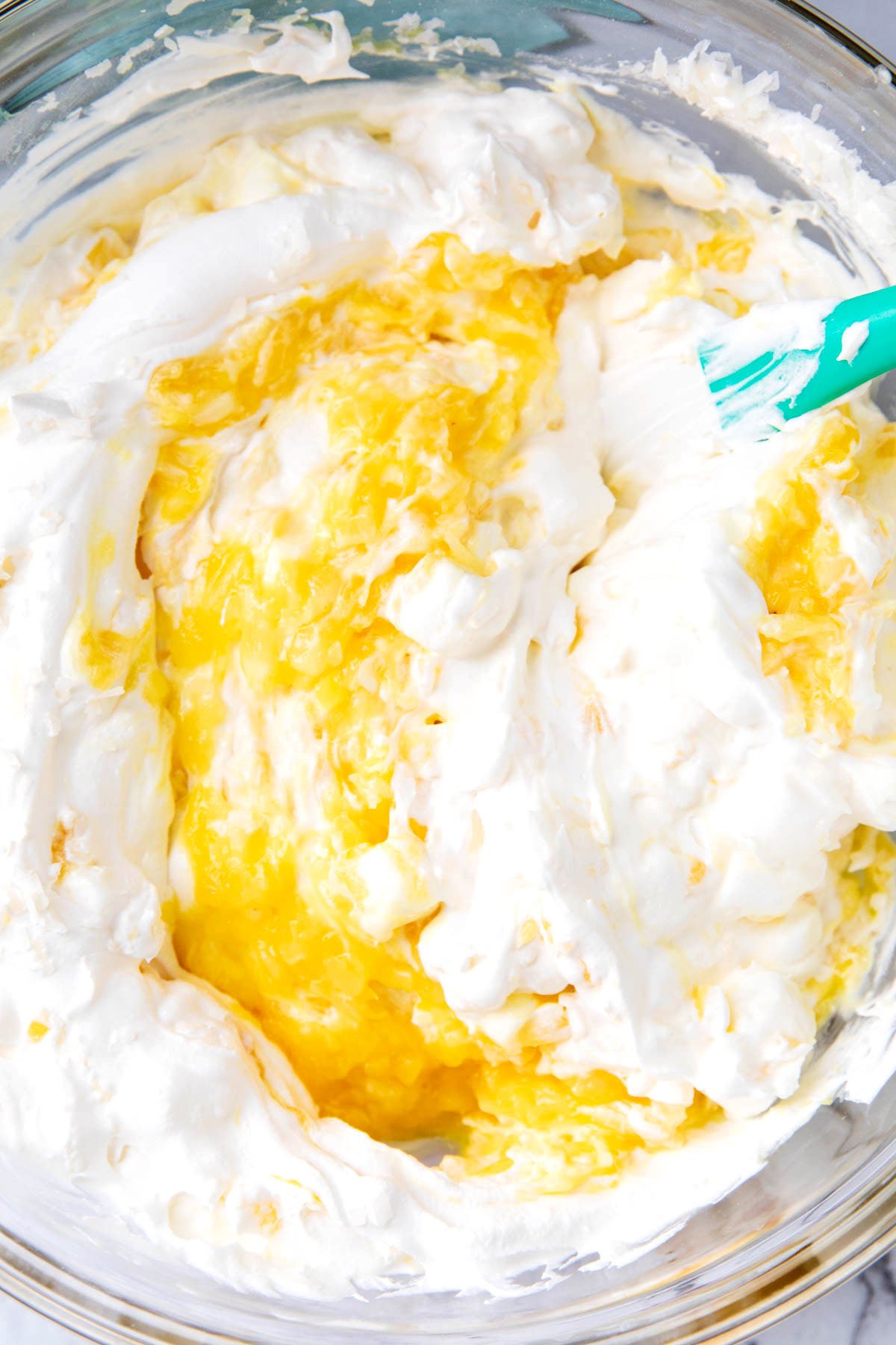 Close up of this pineapple fluff recipe with Cool whip and pineapple stirred together.