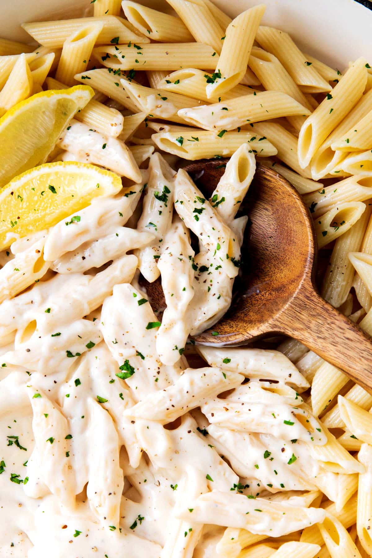 Scooping up Alfredo Penne Pasta loaded with bouncy pasta and lots of homemade Alfredo sauce.
