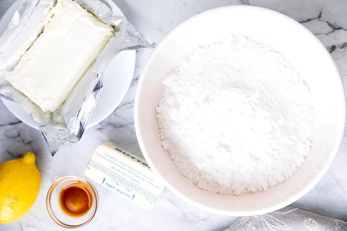 Lemon cream cheese frosting recipe ingredients - cream cheese, butter, confectioners's sugar, lemon juice, lemon zest, and vanilla extract.