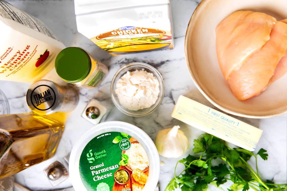 Creamy garlic parmesan chicken recipe ingredients include chicken breasts, chicken broth, garlic, parmesan, butter, heavy cream, Italian seasoning, garlic powder, flour, and salt and pepper.