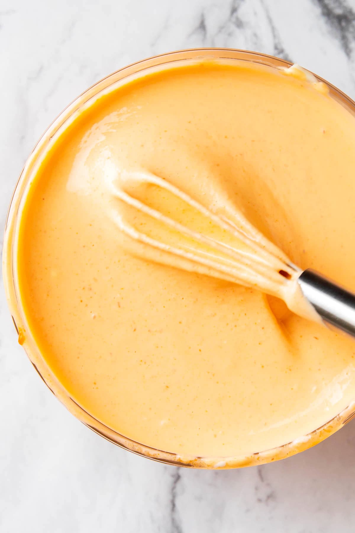 Close up of sriracha mayo shows this homemade condiment is creamy and thick with spicy notes.