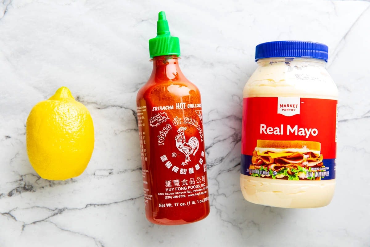 Homemade mayo sriracha sauce ingredients include sriracha, mayonnaise, and a lemon.