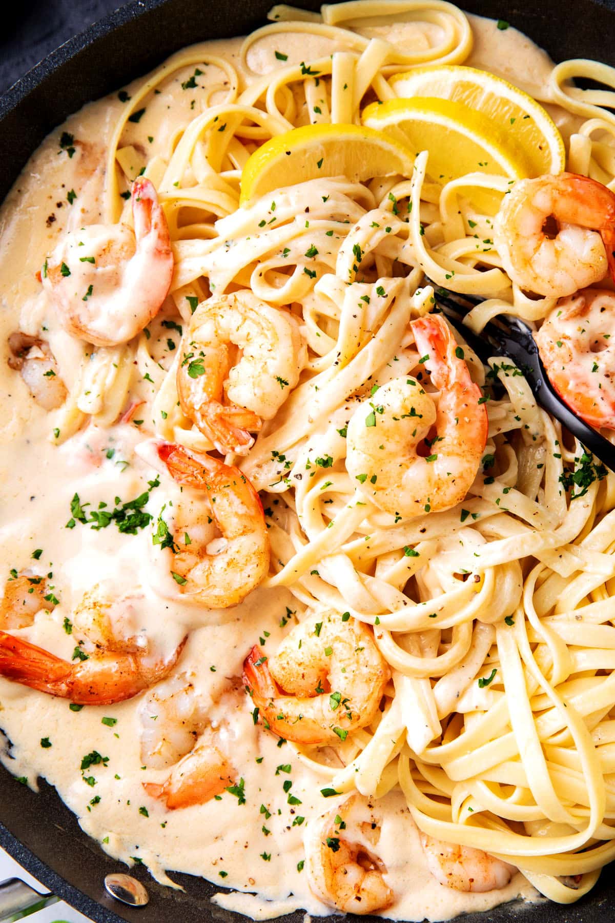 Garlic shrimp Alfredo pasta recipe served with loads of Alfredo, penne pasta, linguine or fettuccine and a sliced lemon.