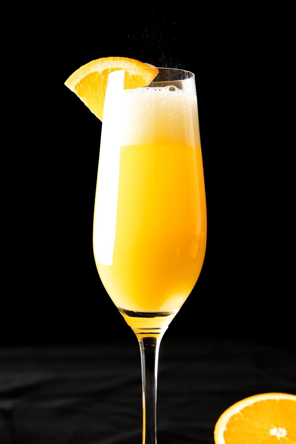 Close up of mimosa recipe with Prosecco with an orange wedge on the champagne rim.