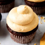 Fluffy, creamy, and smooth peanut butter frosting recipe for chocolate cake is piped onto a cupcake