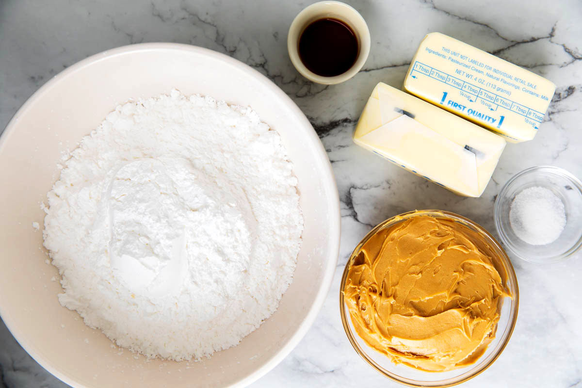 3 ingredient peanut butter frosting with powdered sugar, butter, peanut butter and vanilla measured in bowls.