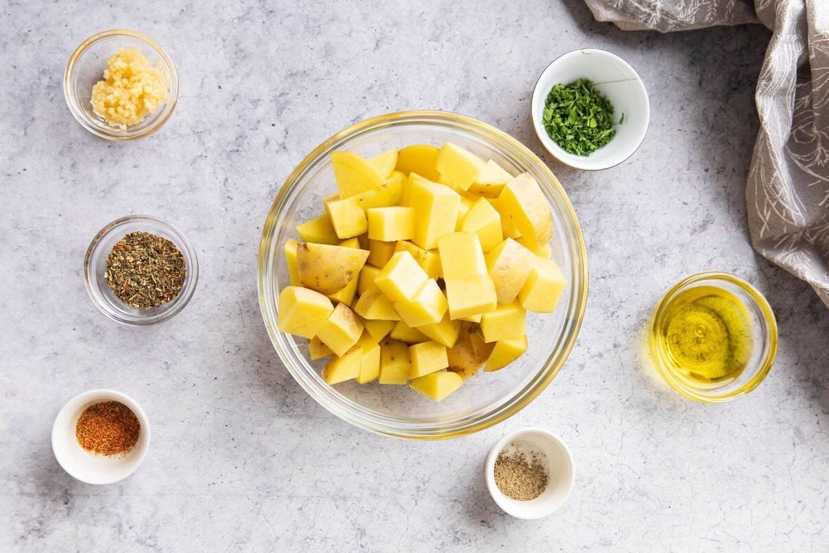Ingredients for Air Fryer Roasted Potatoes including Yukon gold potatoes, seasonings, and olive oil.