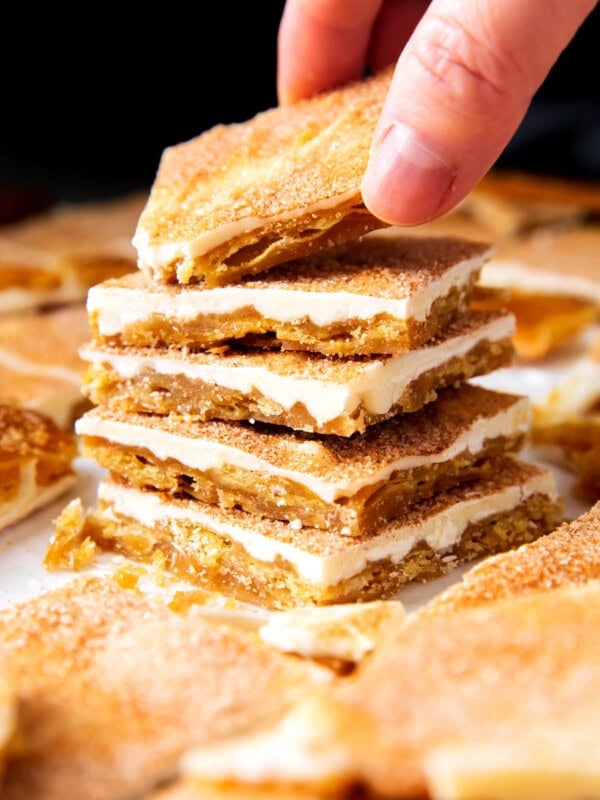 Someone grabbing a piece os this churro crack recipe from a stack
