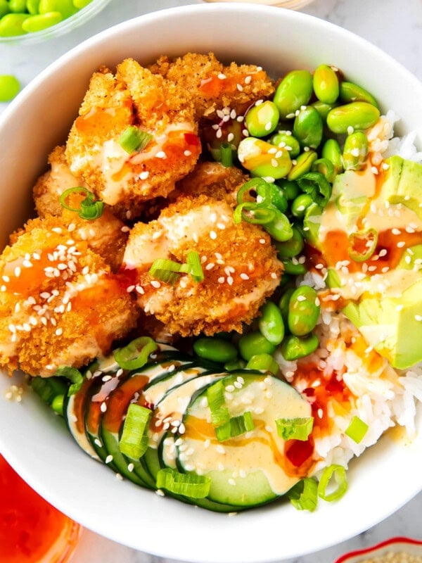 This Asian shrimp bowl feature crispy fried shrimp, edamame, avocado, yum yum sauce, and Thai sweet chili
