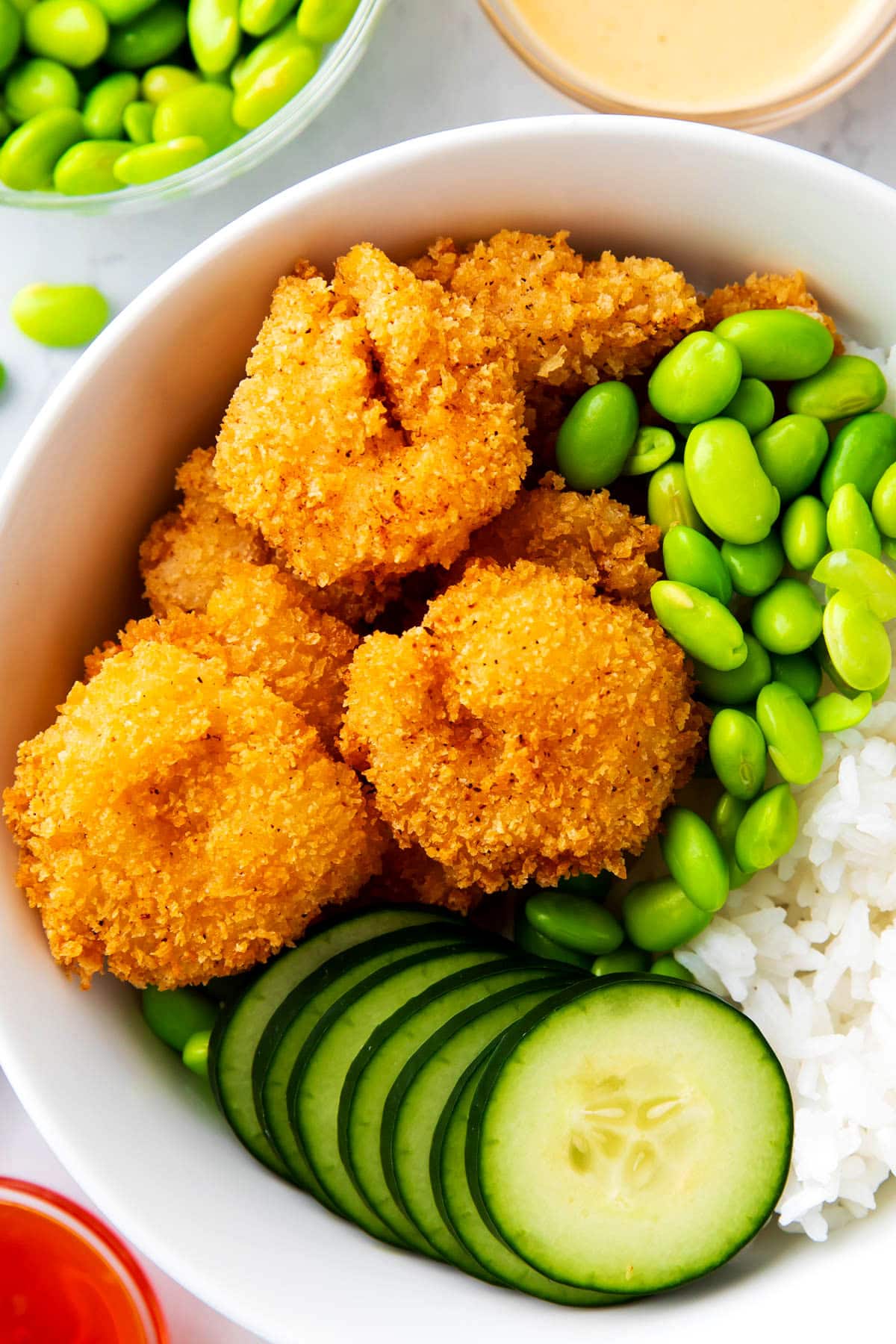 An abundance of crispy fried shrimp top this shrimp edamame bowl.