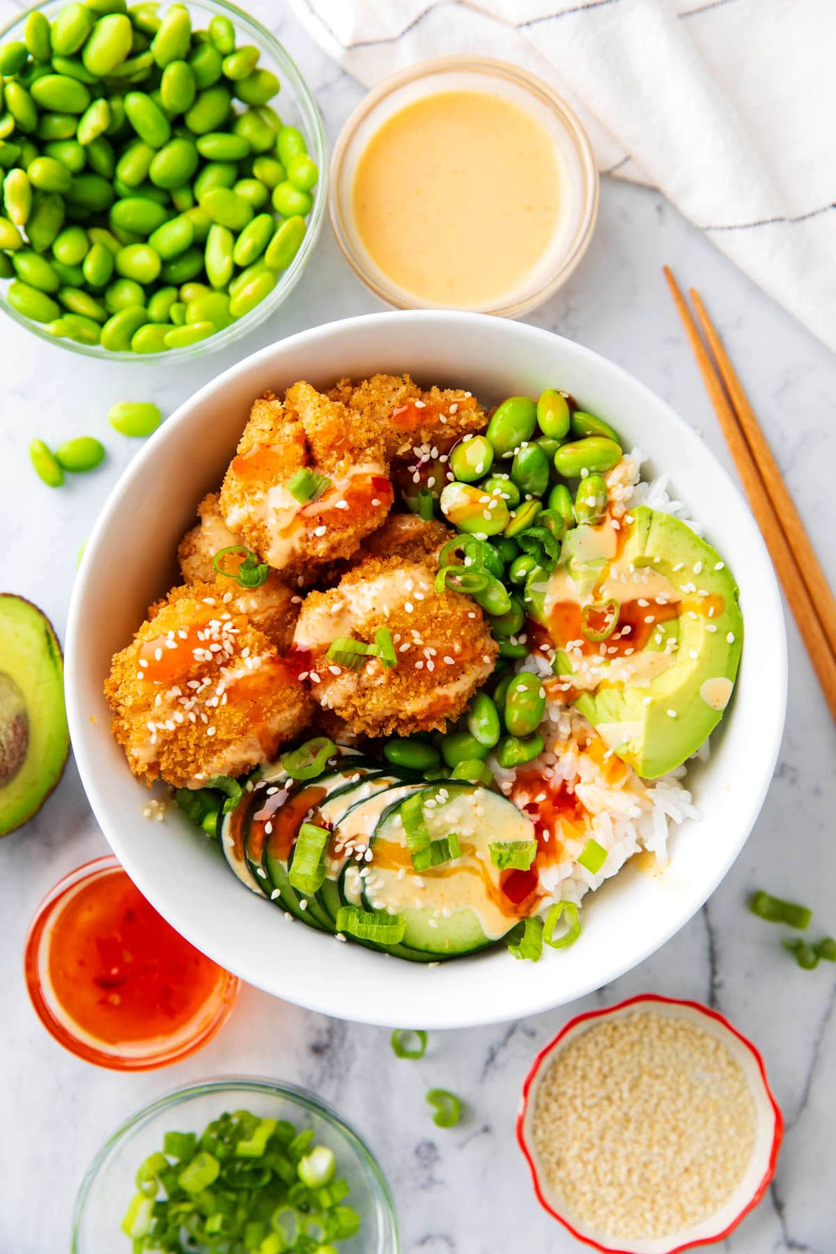 Creamy and sweet sauces are drizzled over this shrimp and avocado rice bowl to make for an easy dinner recipe.
