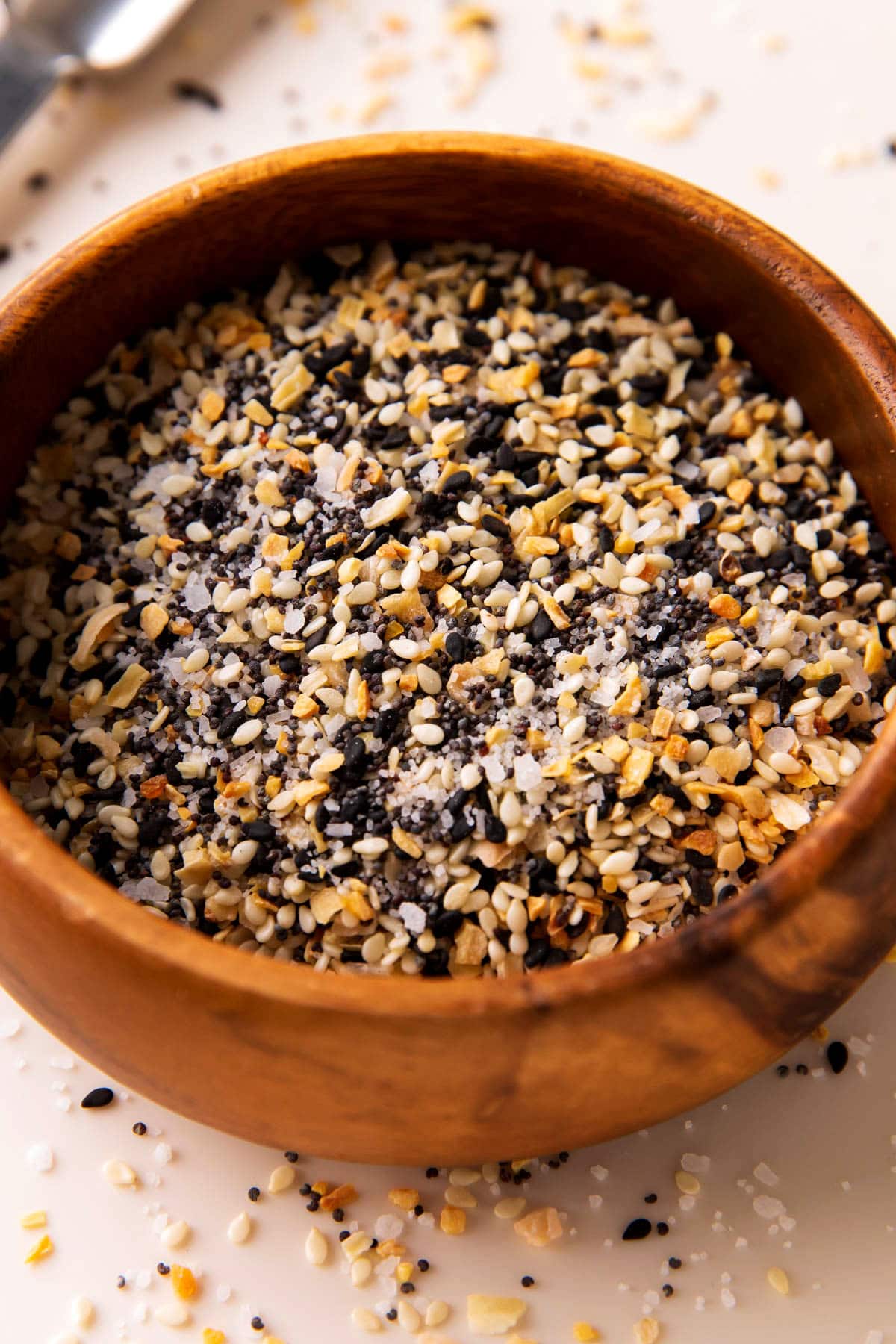 Close up of everything but the bagel seasoning recipe shows flaky sea salt, poppy seeds, white and black sesame seeds and dried onion and garlic.
