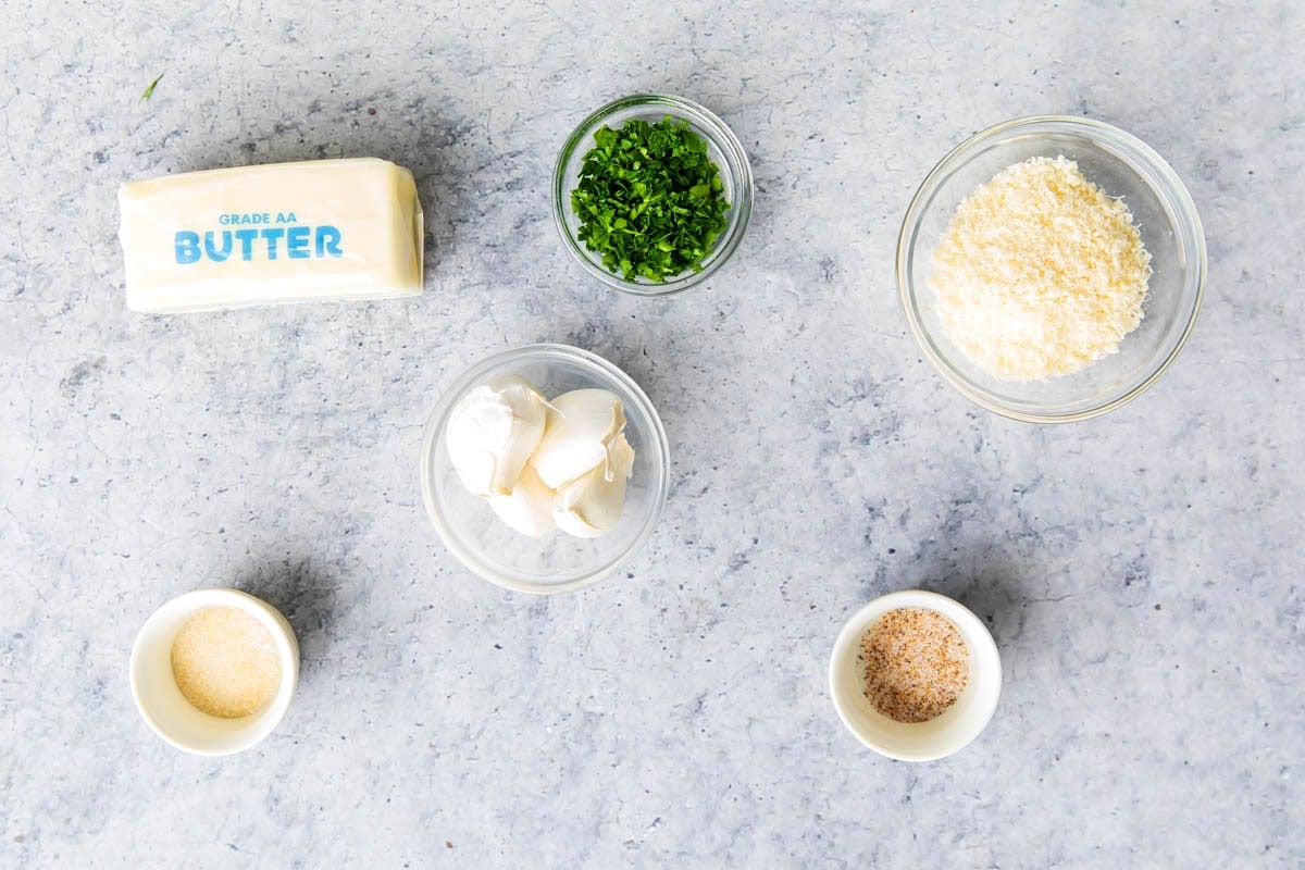 Garlic Butter ingredients in prep bowls including butter, garlic powder, garlic salt, Parmesan, chives, and seasoned salt.