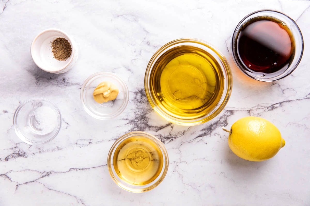 Maple Vinaigrette ingredients in prep bowls including maple syrup, olive oil, apple cider vinegar, Dijon mustard, salt and pepper.