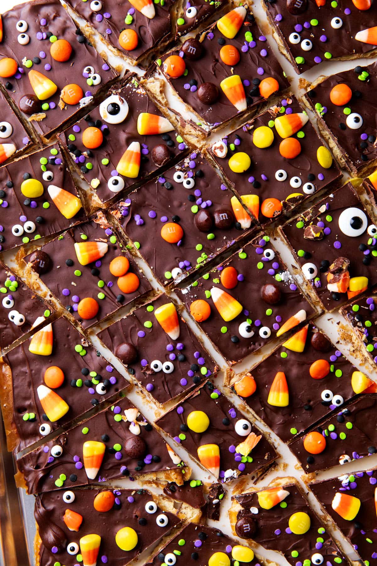 Homemade toffee bark recipe sliced into pieces with loads of chocolate and spooky sprinkles on top.