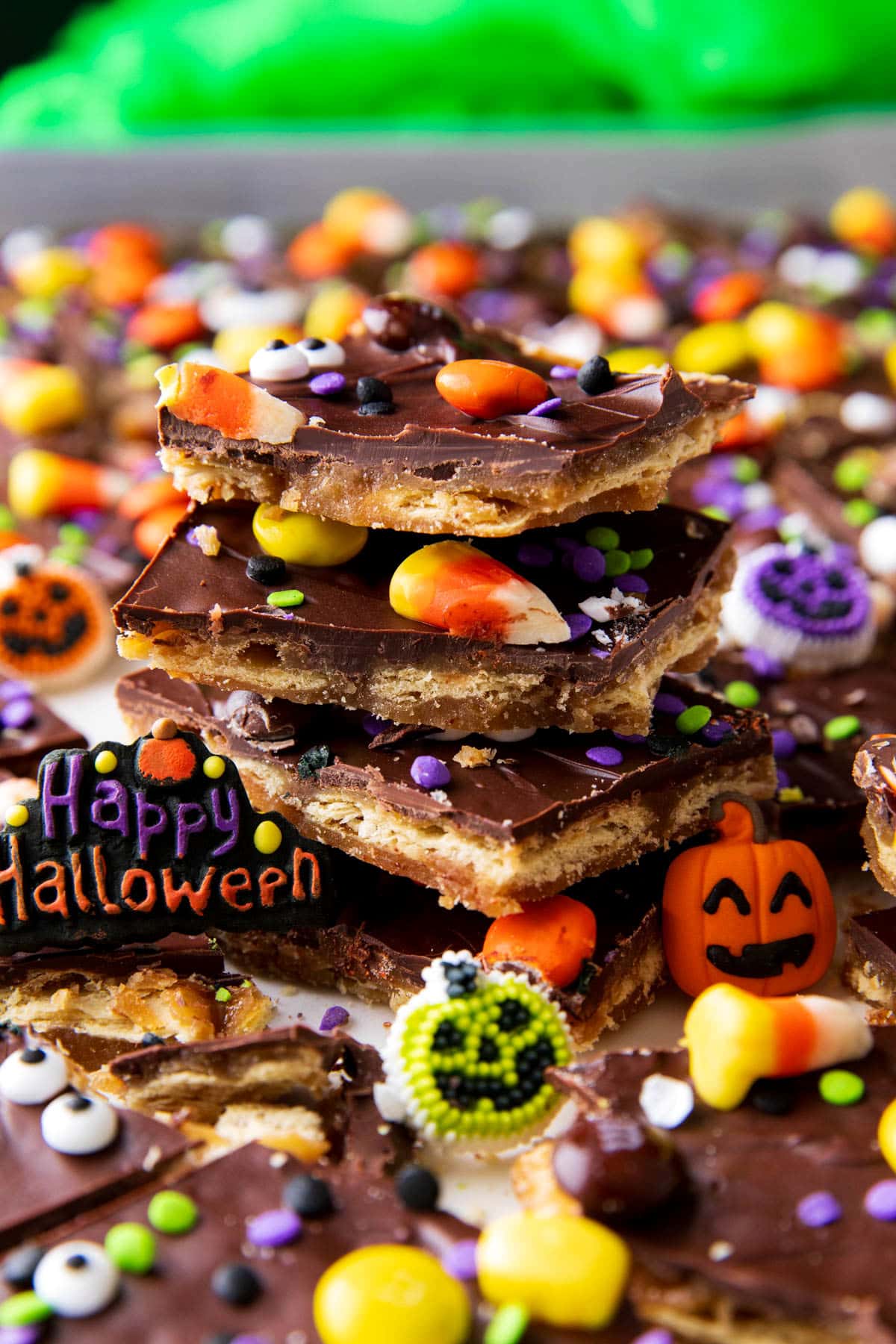 Stacks of homemade toffee with jack-o-lantern and Happy Halloween dessert toppers and Halloween party decor.