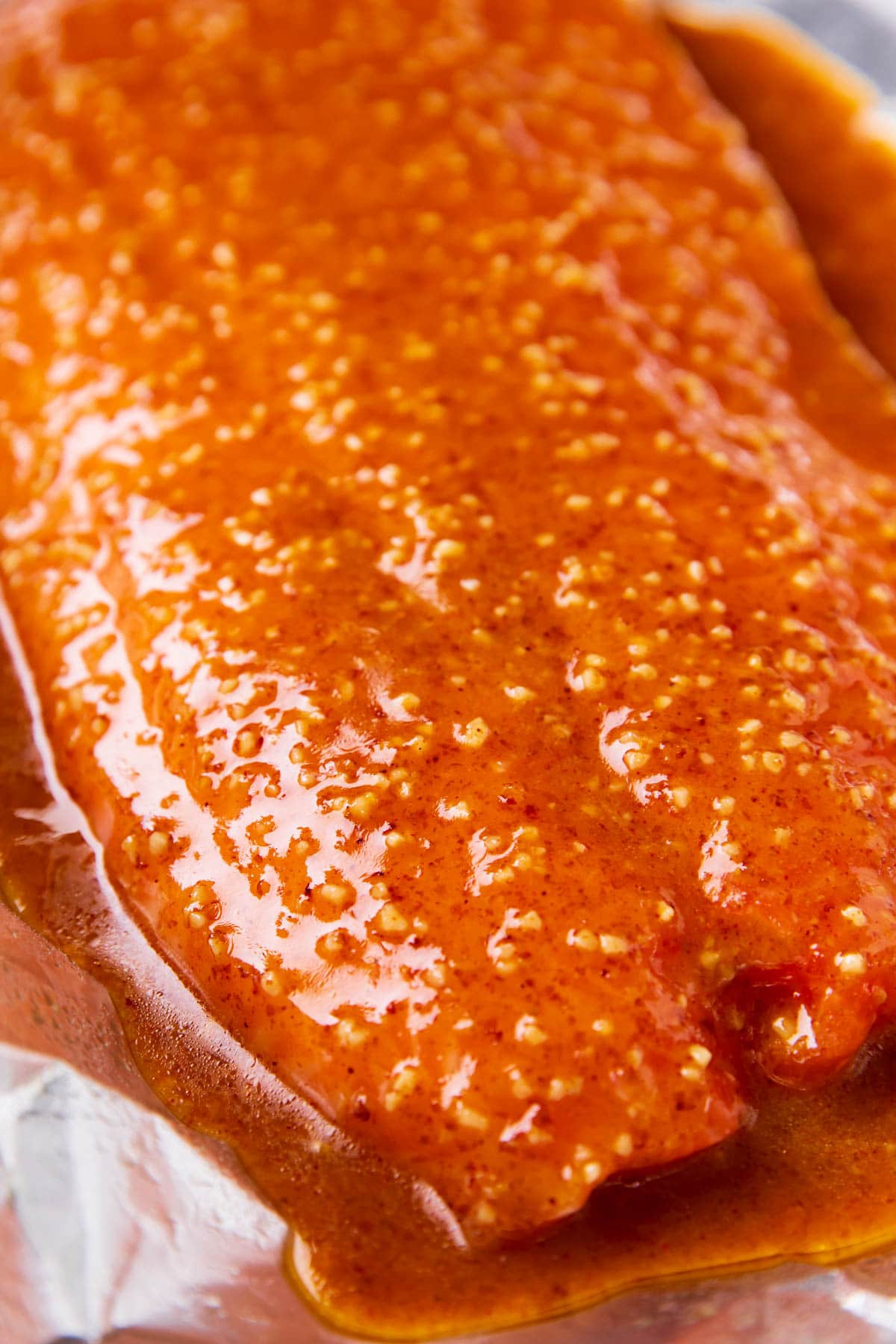 Salmon is fully coated in honey mustard marinade before baking.