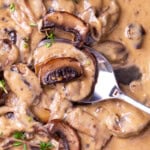 Close up of a spoon filled with Mushroom Sauce to show rich and creamy texture