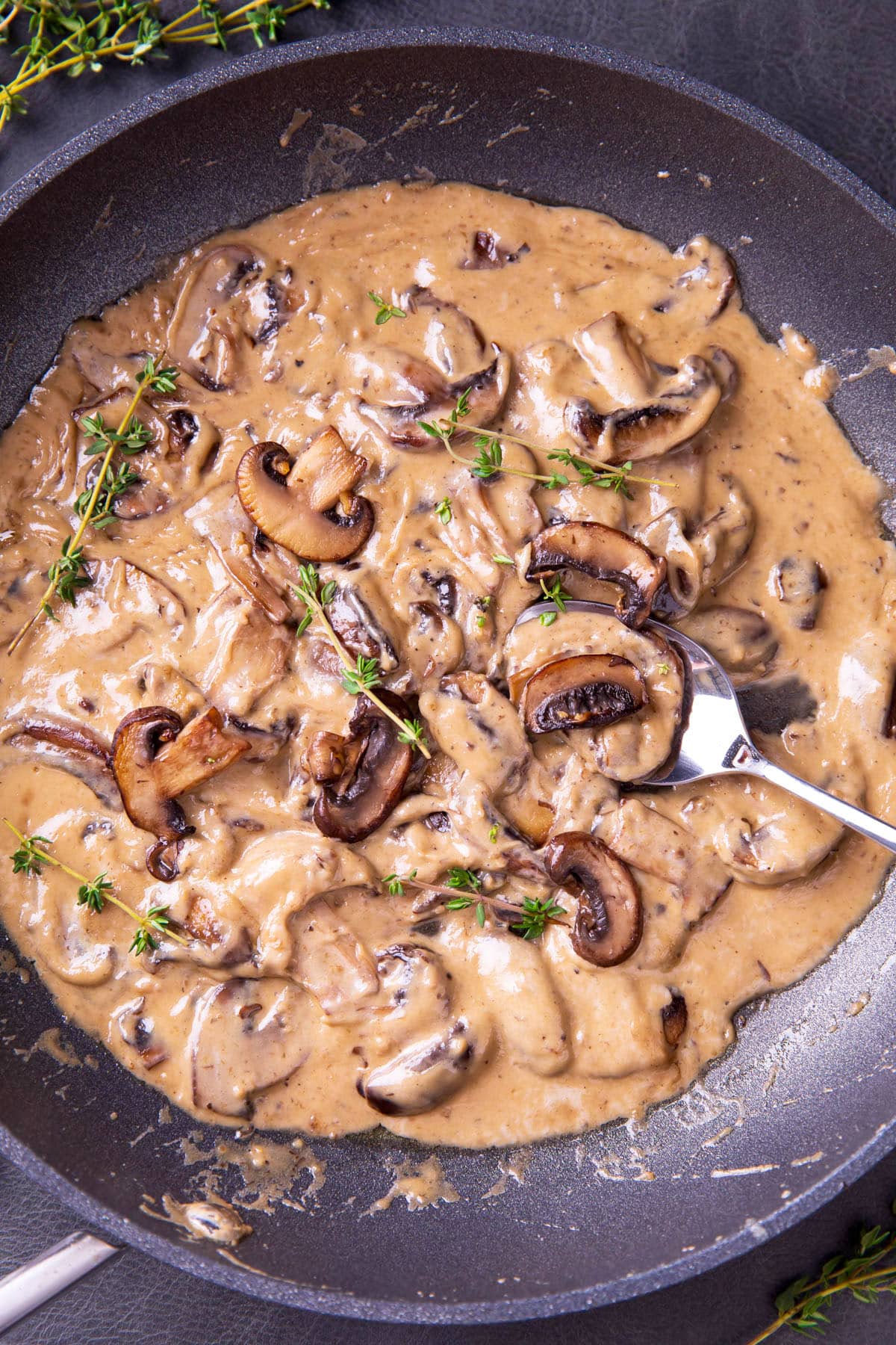 Creamy Mushroom Sauce cooked in a skillet with lots of sautéed mushrooms.