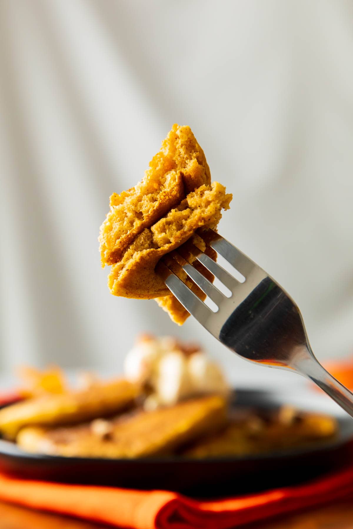 A fork holds up two bites of this breakfast recipe to show fluffy, airy texture.