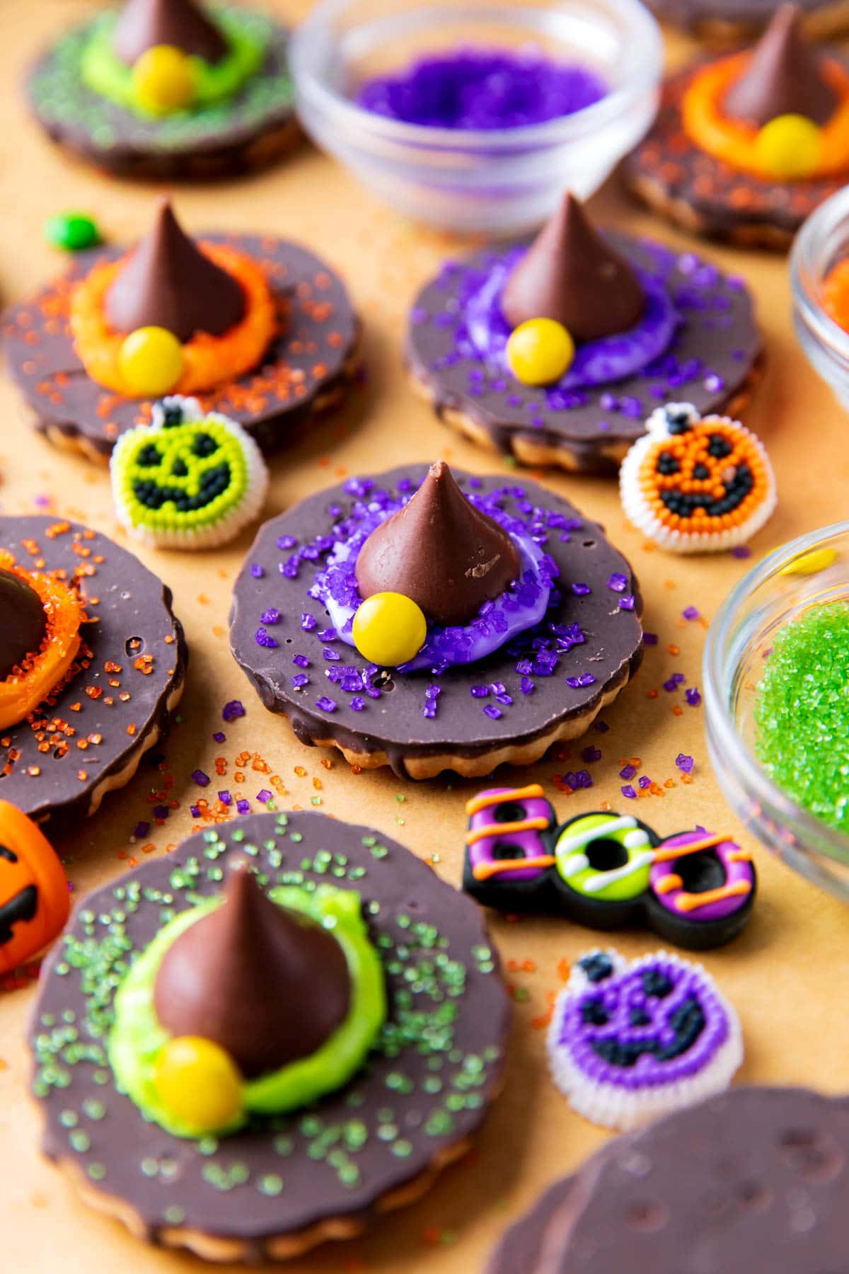 A tray of easy Halloween treats for a Halloween party that includes decorating ingredients like bowls of purple, green, and orange sugar and Halloween sprinkles.