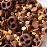 Close up of peanut butter cup trail mix shows delicious textured ingredients including salty peanuts, sweet peanut butter cups, milk chocolate covered pretzels and more.