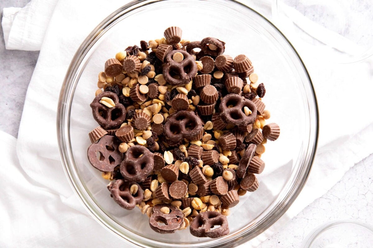 A photo showing How to Make Peanut Butter Trail Mix - fully stirred together in a mixing bowl.